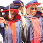 Graduands adjust their tussles after being conferred PhD degrees