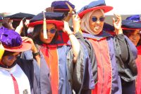 Graduands adjust their tussles after being conferred PhD degrees